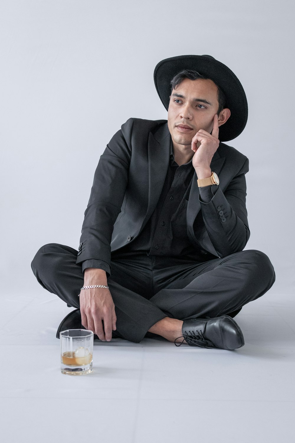 man in black suit jacket and black pants sitting on floor