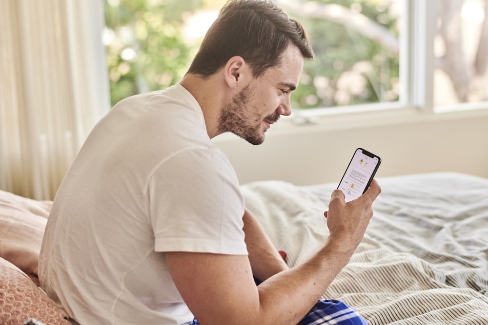 Un homme sur un lit travaillant à la signature d’un contrat avec Docusign