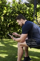 A person watching sports on a tablet while relaxing outdoors.
