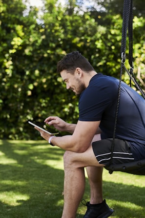 A person watching sports on a tablet while relaxing outdoors.