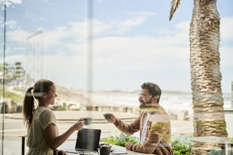 man in brown jacket sitting beside with woman at coffee shop