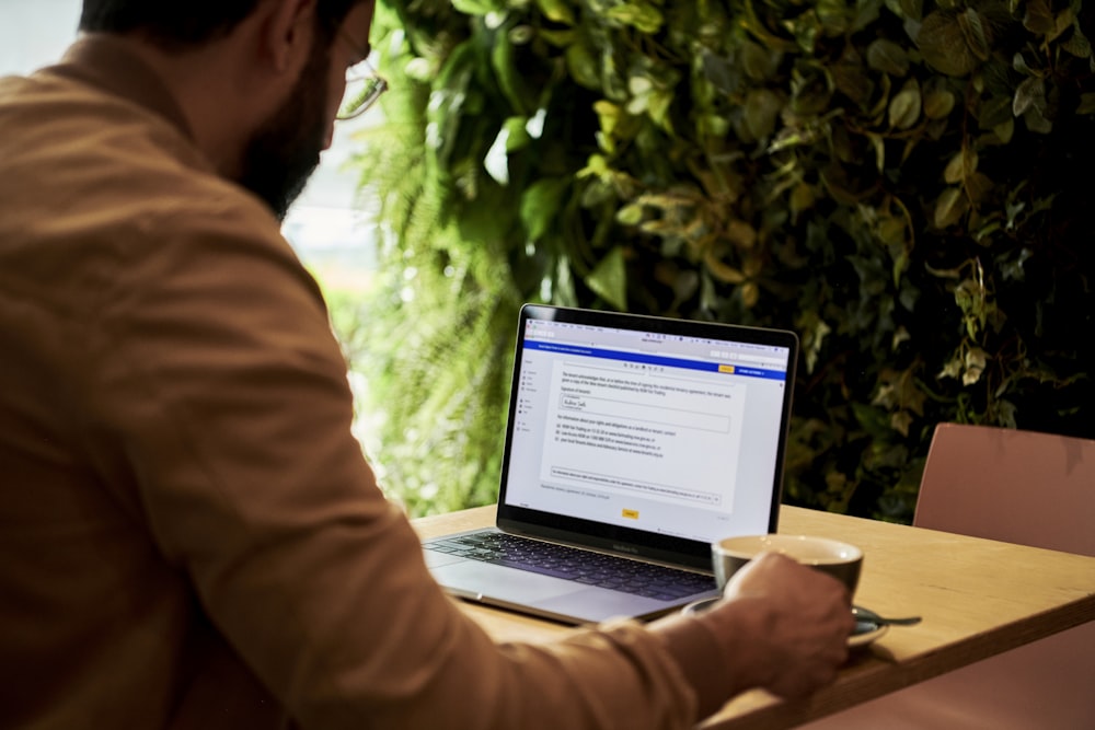 hombre en chaqueta marrón mirando el contrato en DocuSign en una computadora portátil