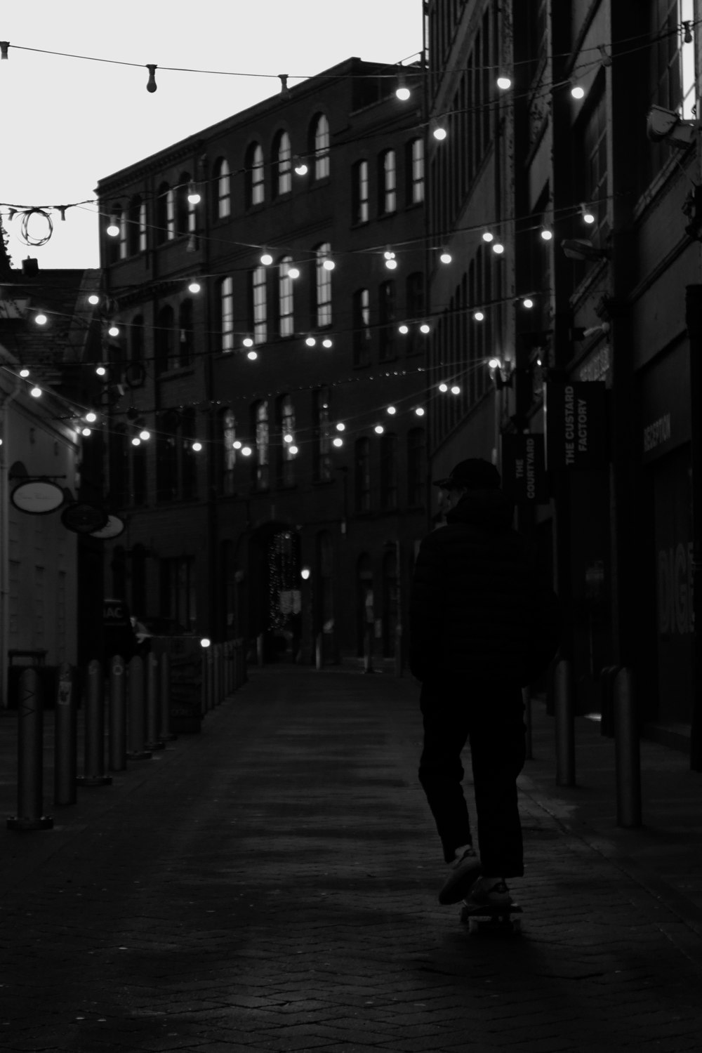 man in black jacket walking on sidewalk during daytime