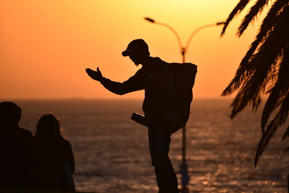 silhouette of man and woman kissing during sunset