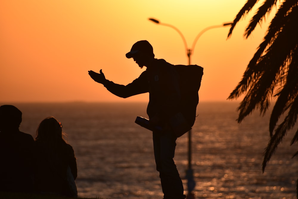 Silueta de hombre y mujer besándose durante la puesta del sol