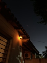 Evening shot of a coastal home with warm light coming from windows, a mini split unit quietly working.