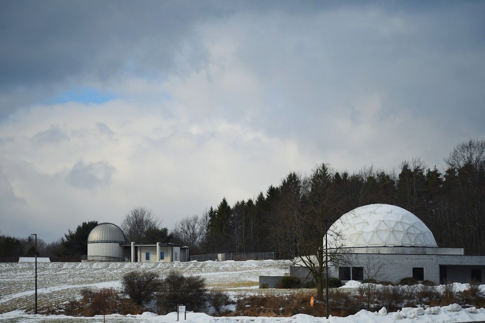 white dome building near trees under white clouds during daytime