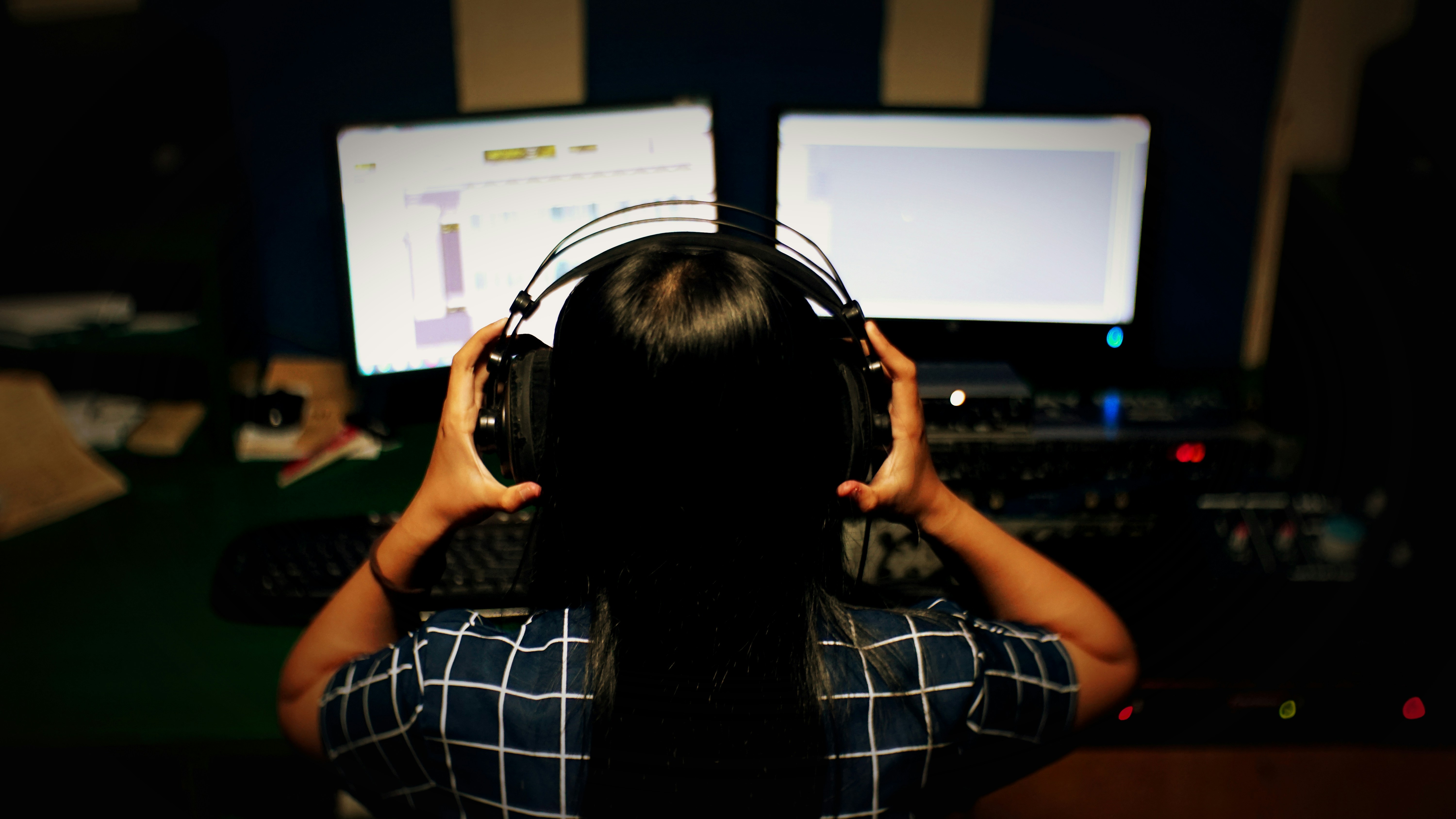 Mujer con camisa a cuadros en blanco y negro con auriculares negros