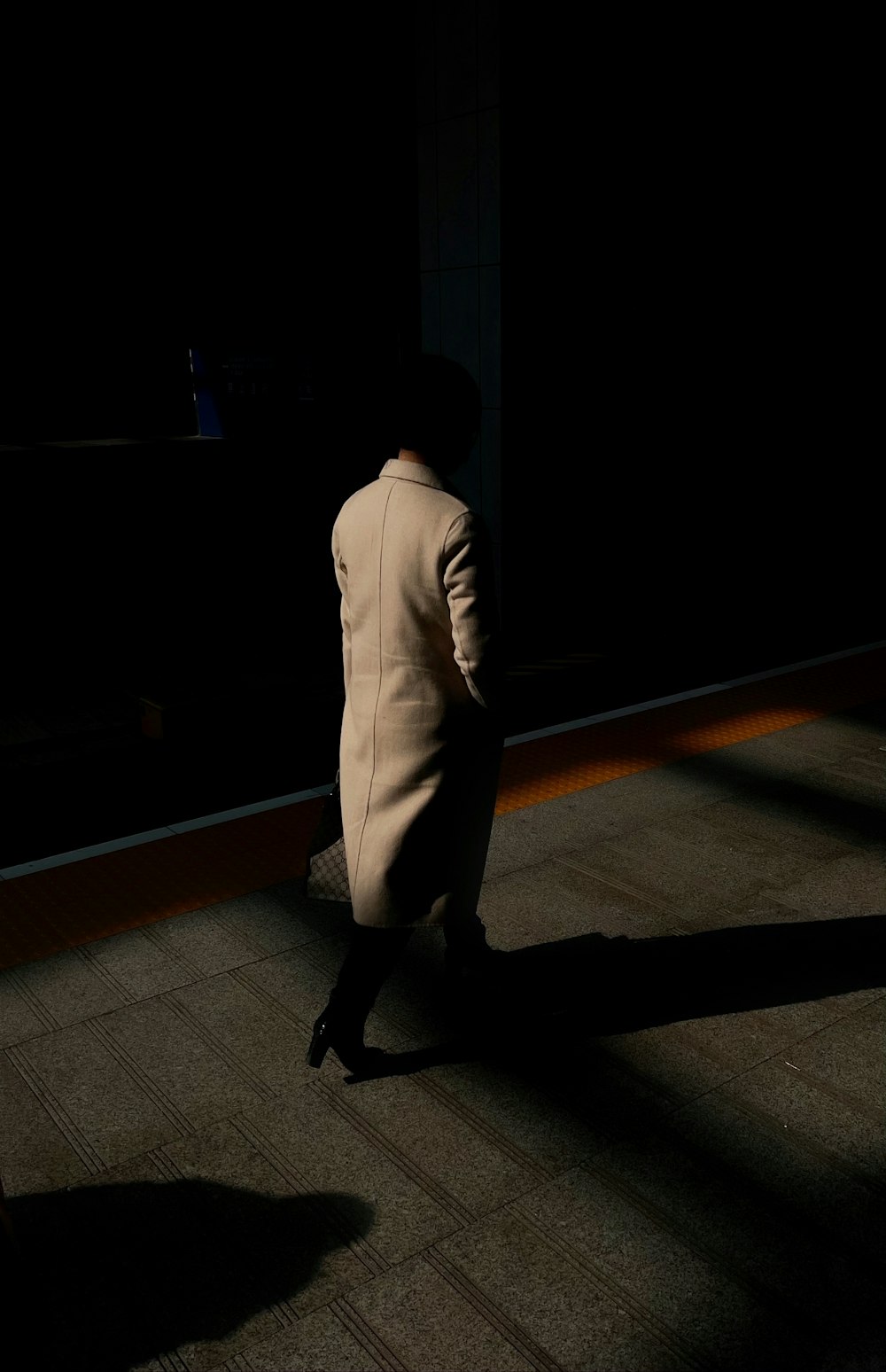 homme en costume blanc marchant sur un plancher en bois brun