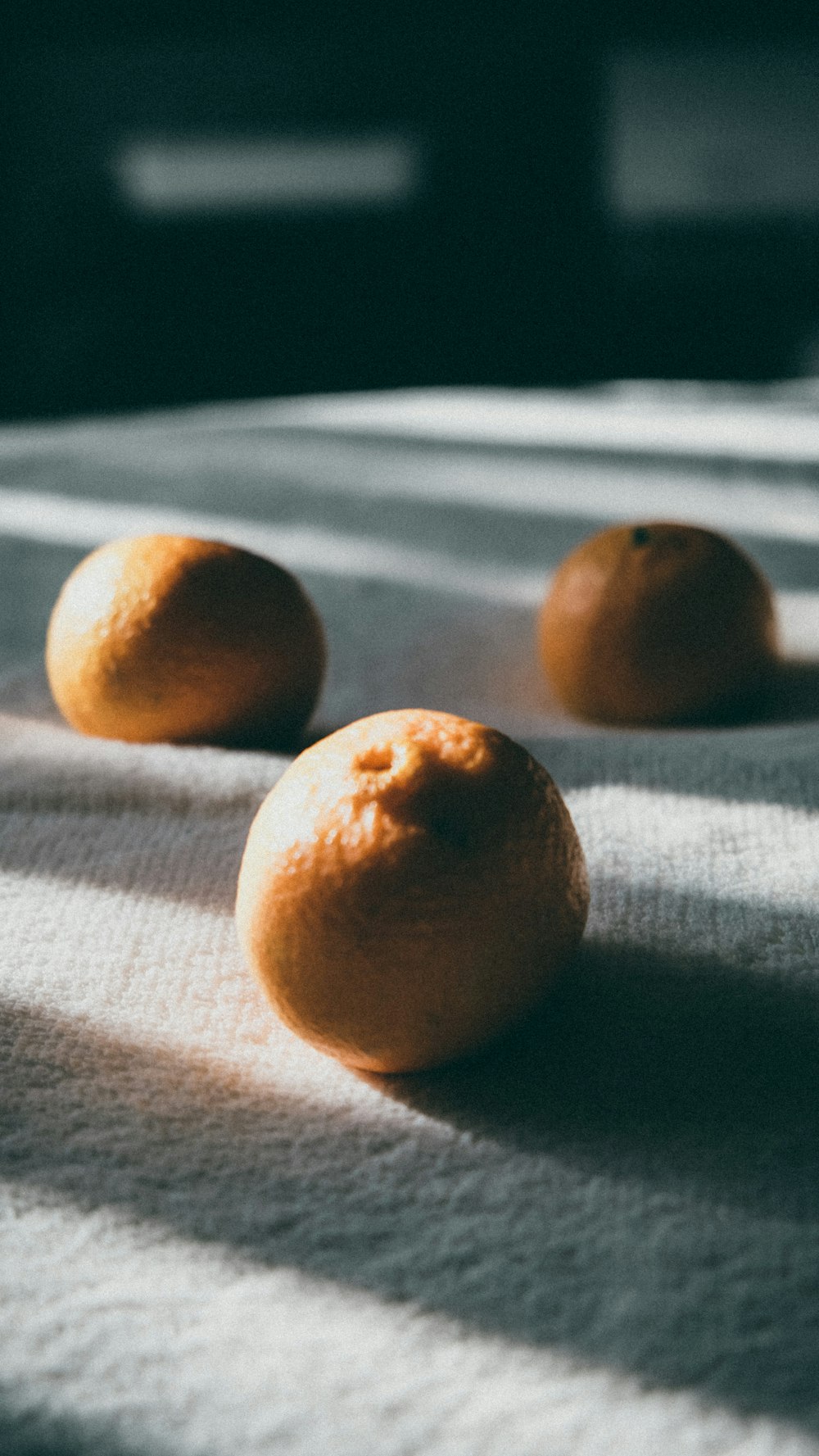 four brown round fruits on gray textile