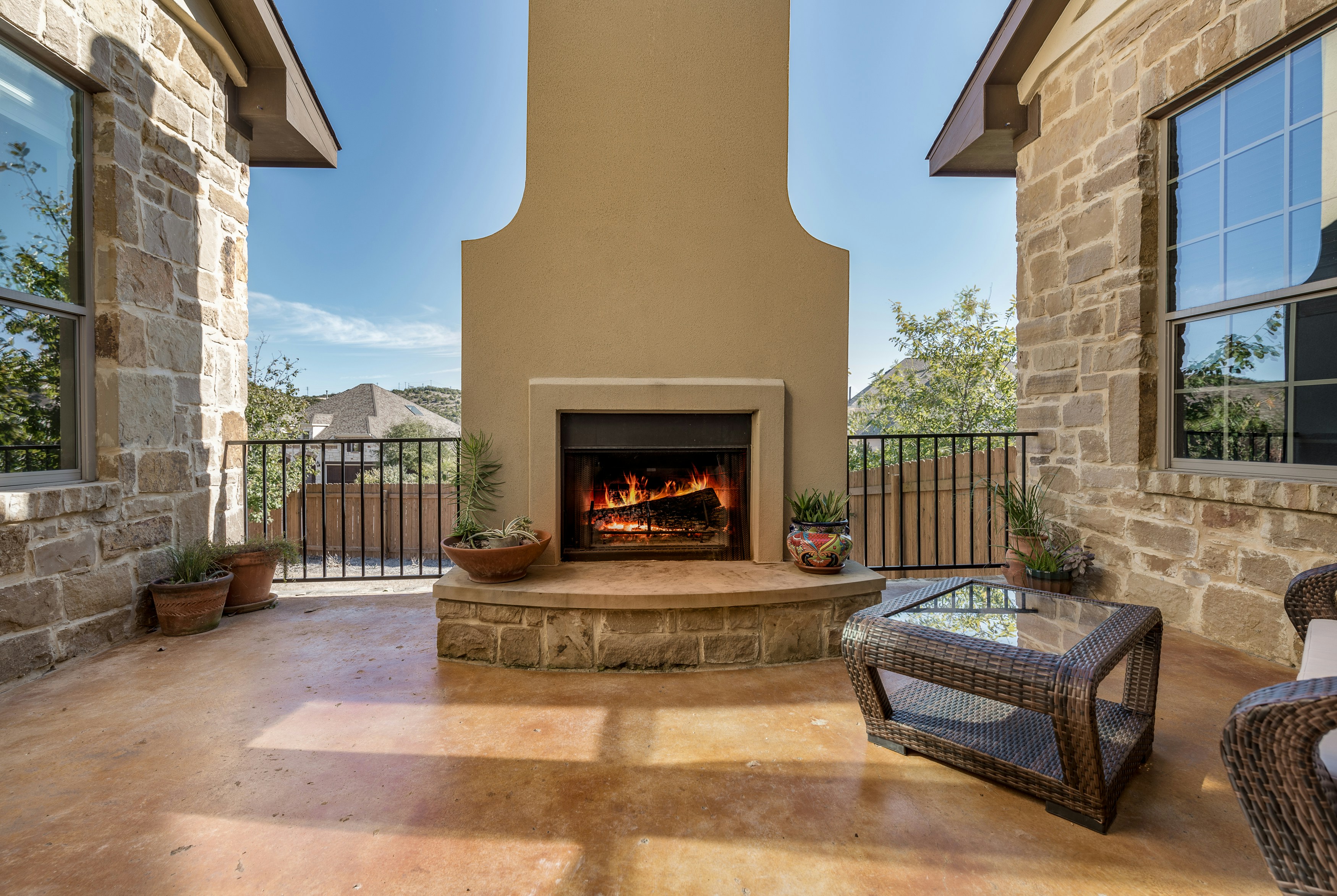 Custom stucco outdoor fireplace on stained concrete patio installed in Galveston, TX