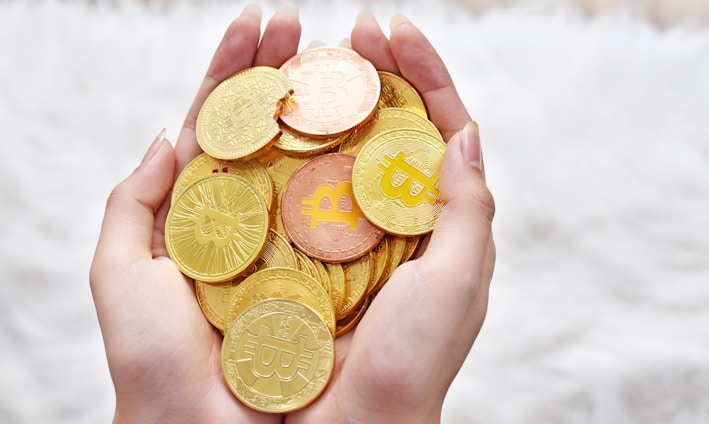 person holding gold round coins