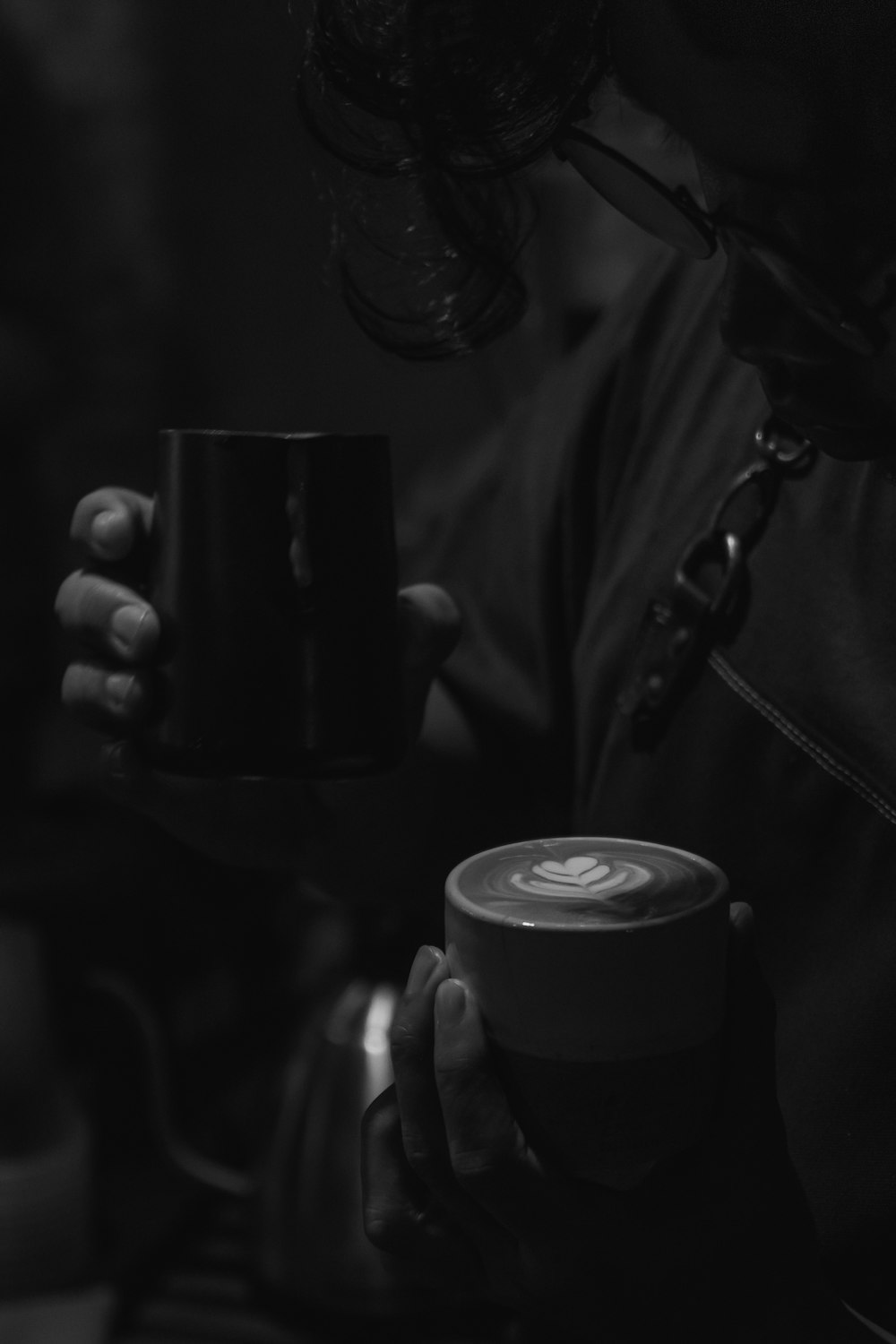 person holding ceramic mug in grayscale photography