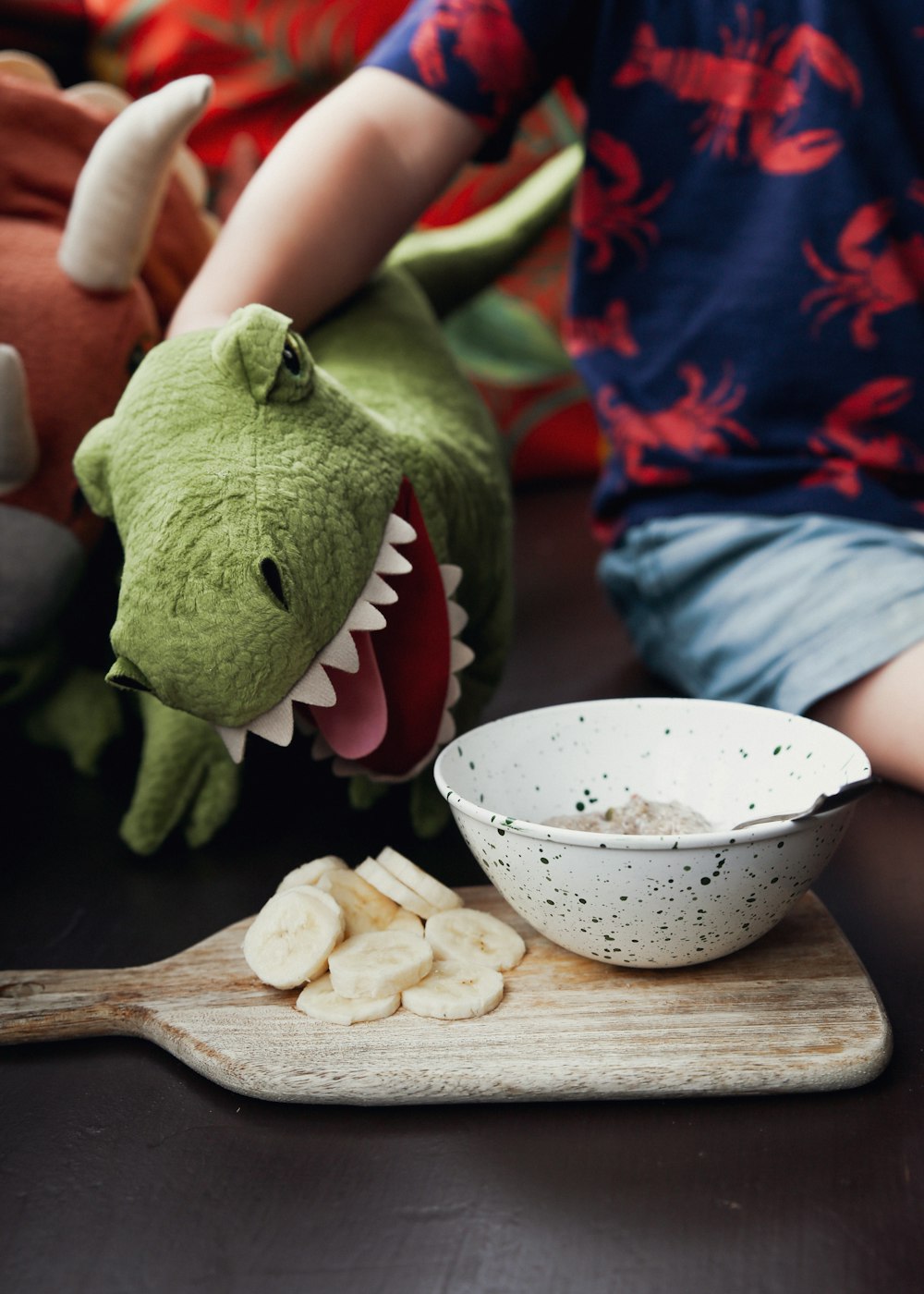 green frog plush toy beside white ceramic bowl