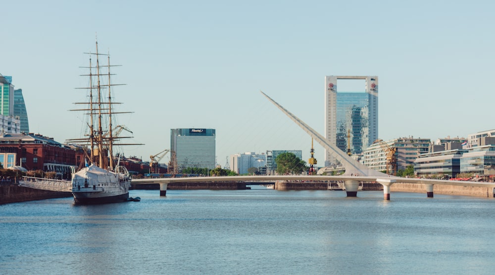 Bateau blanc et noir sur l’eau près du pont pendant la journée