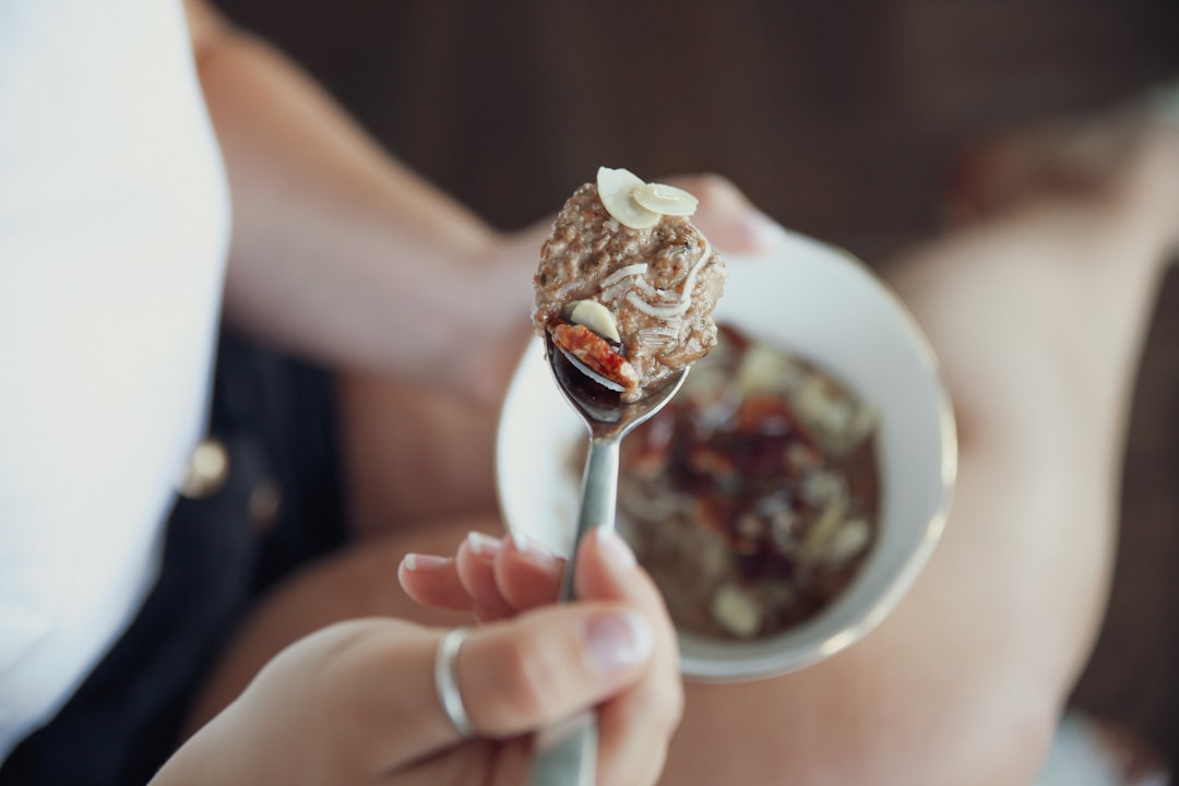 person holding ice cream on white ceramic bowl