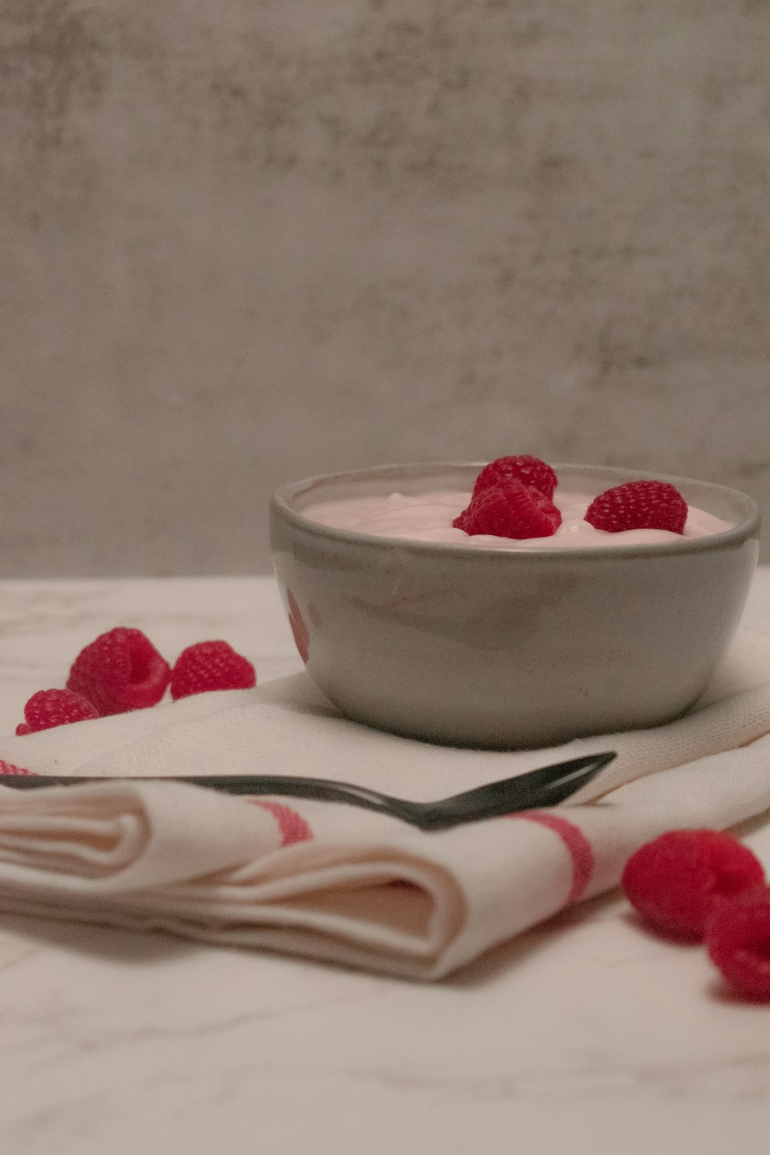 white ceramic bowl with strawberry on white textile