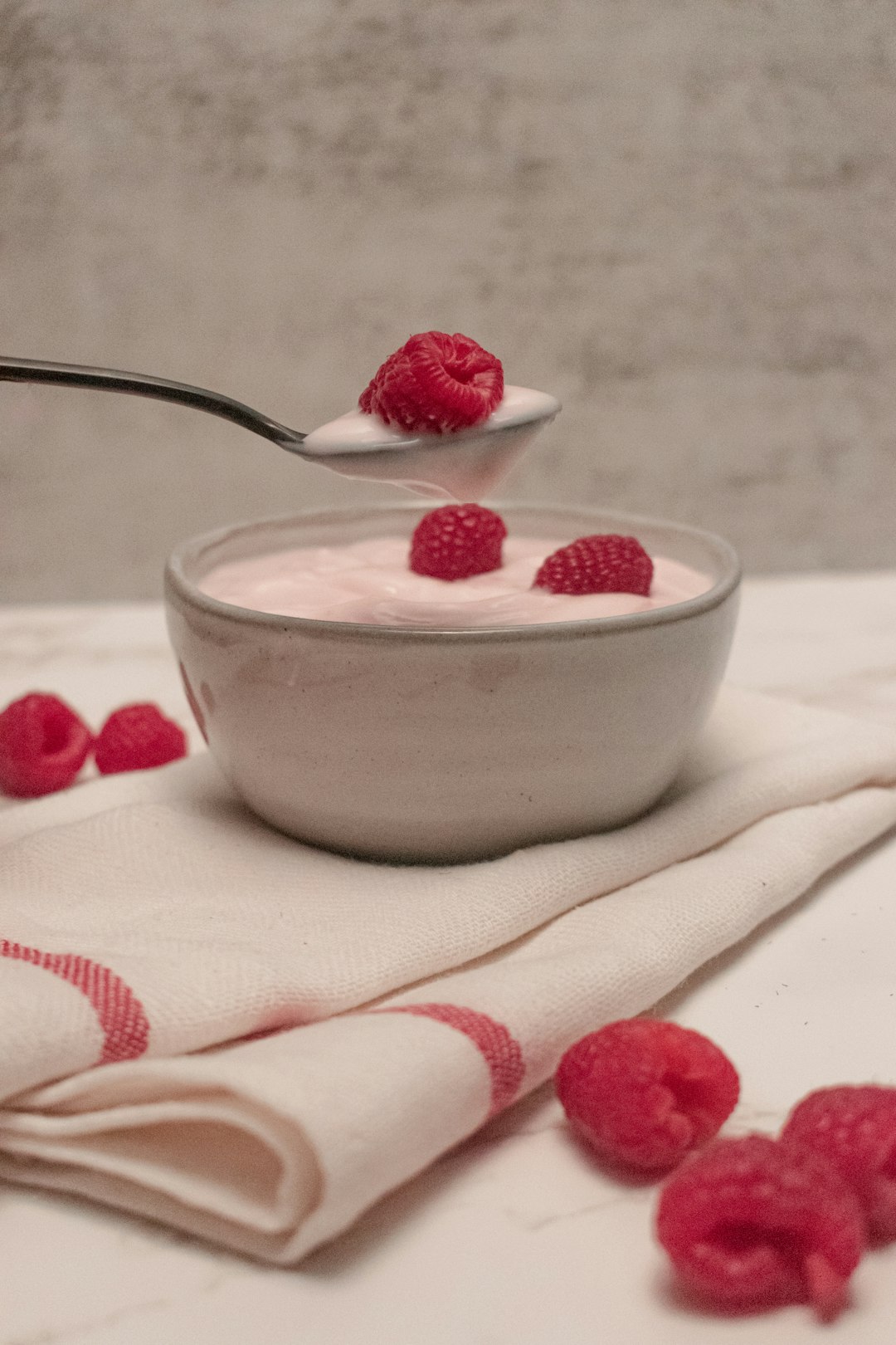 white ceramic bowl with strawberry on white and red textile