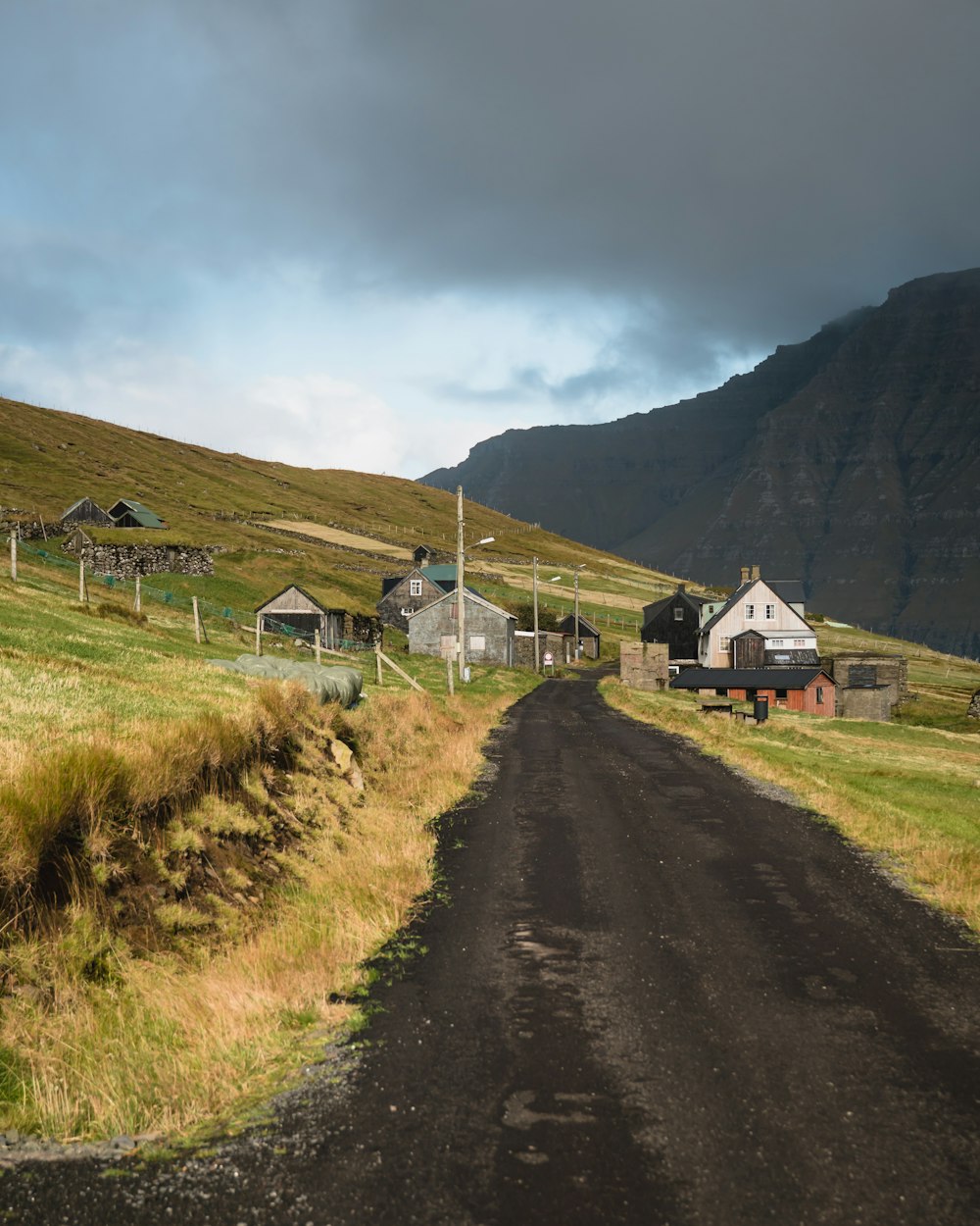 white and brown house near mountain under white clouds during daytime