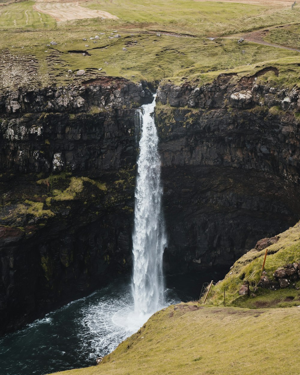 waterfalls on brown rocky mountain during daytime