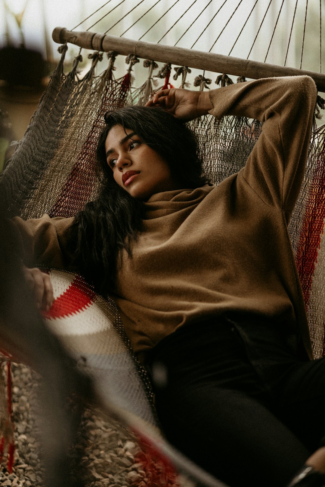 woman in brown sweater lying on bed