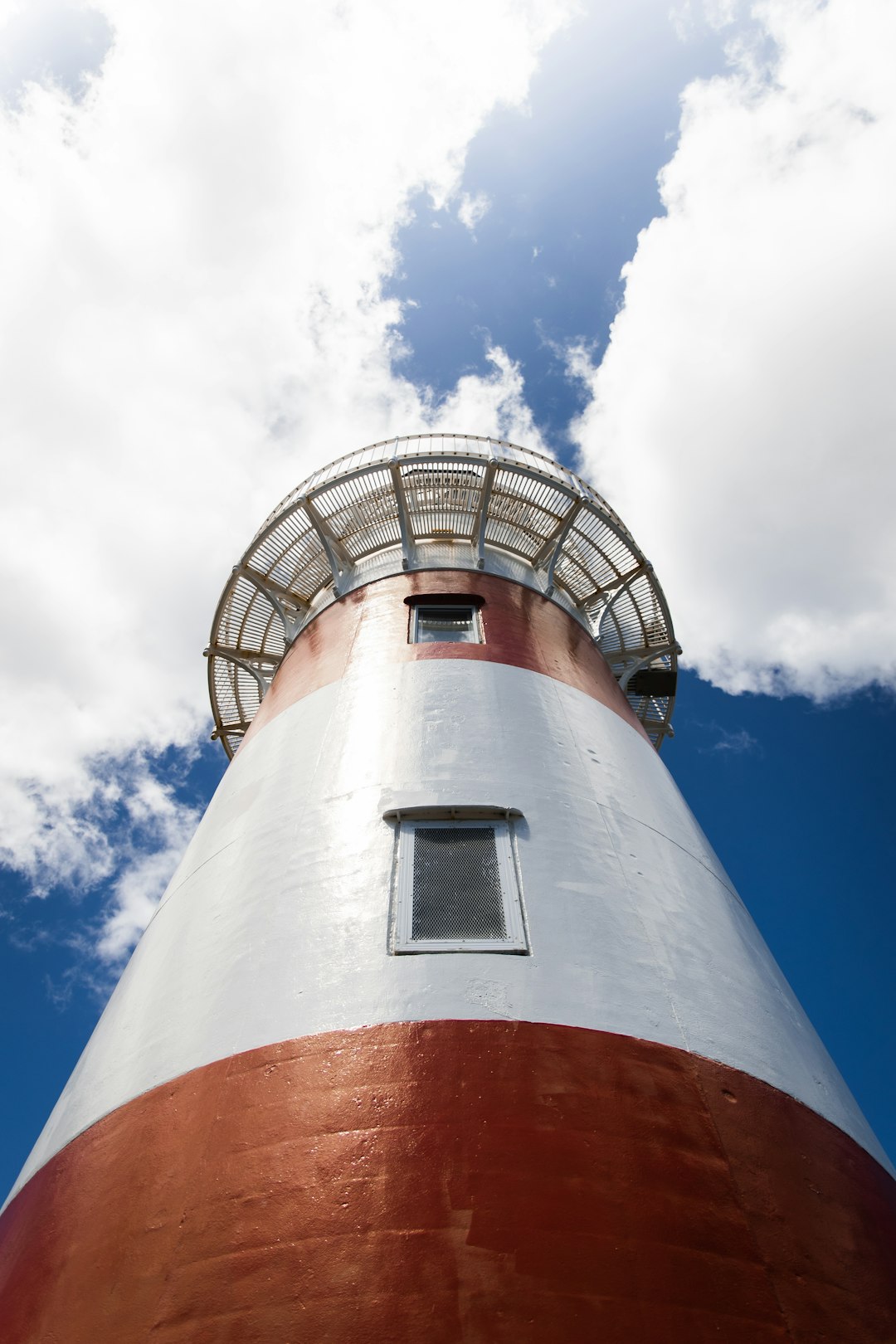 white and red concrete lighthouse under blue sky during daytime