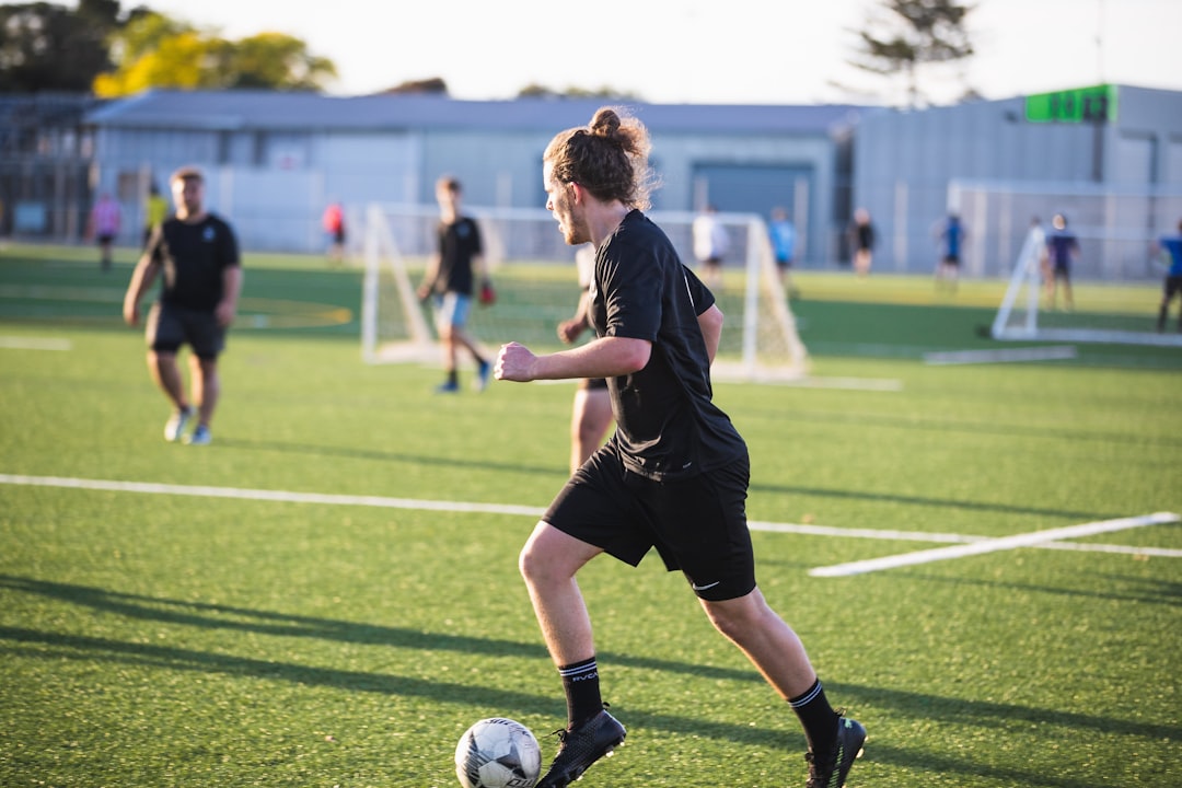 woman in black shirt and shorts playing soccer during daytime