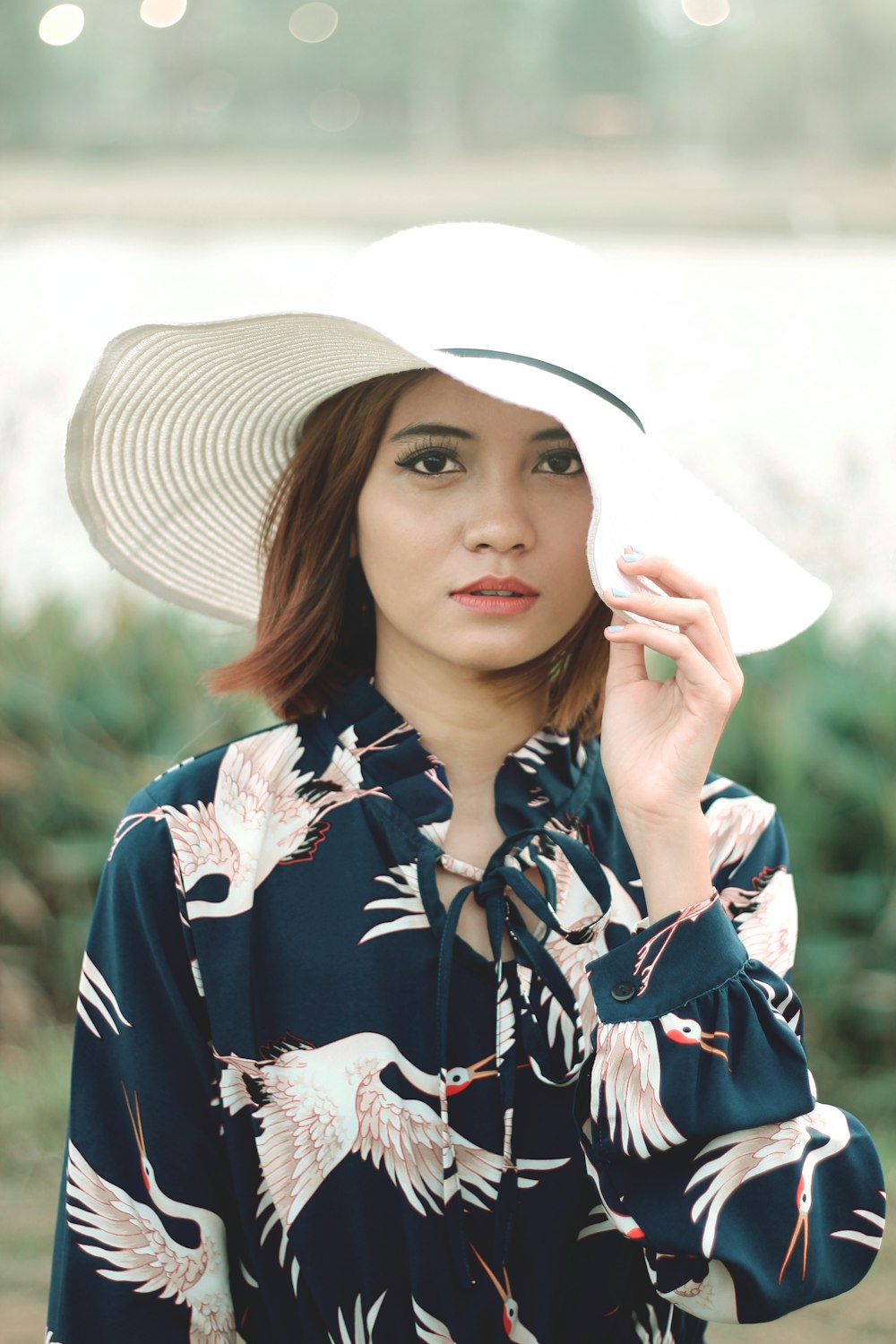 woman in black and white floral button up shirt wearing brown straw hat