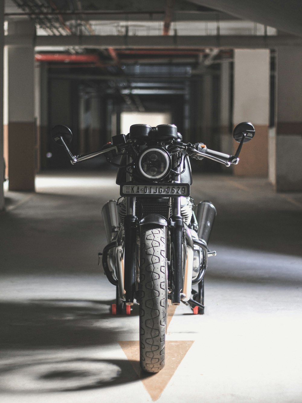 Motocicleta negra estacionada en pavimento gris