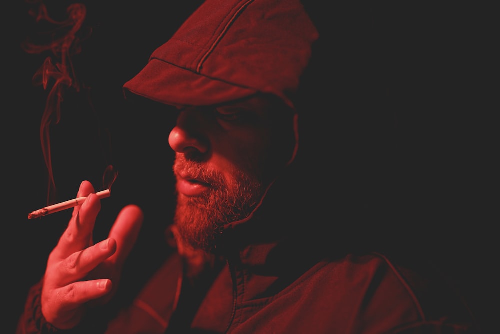 man in red hoodie smoking cigarette