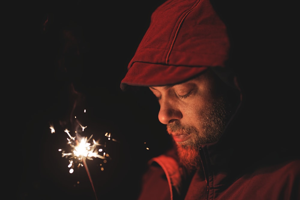 man in red hoodie holding sparkler