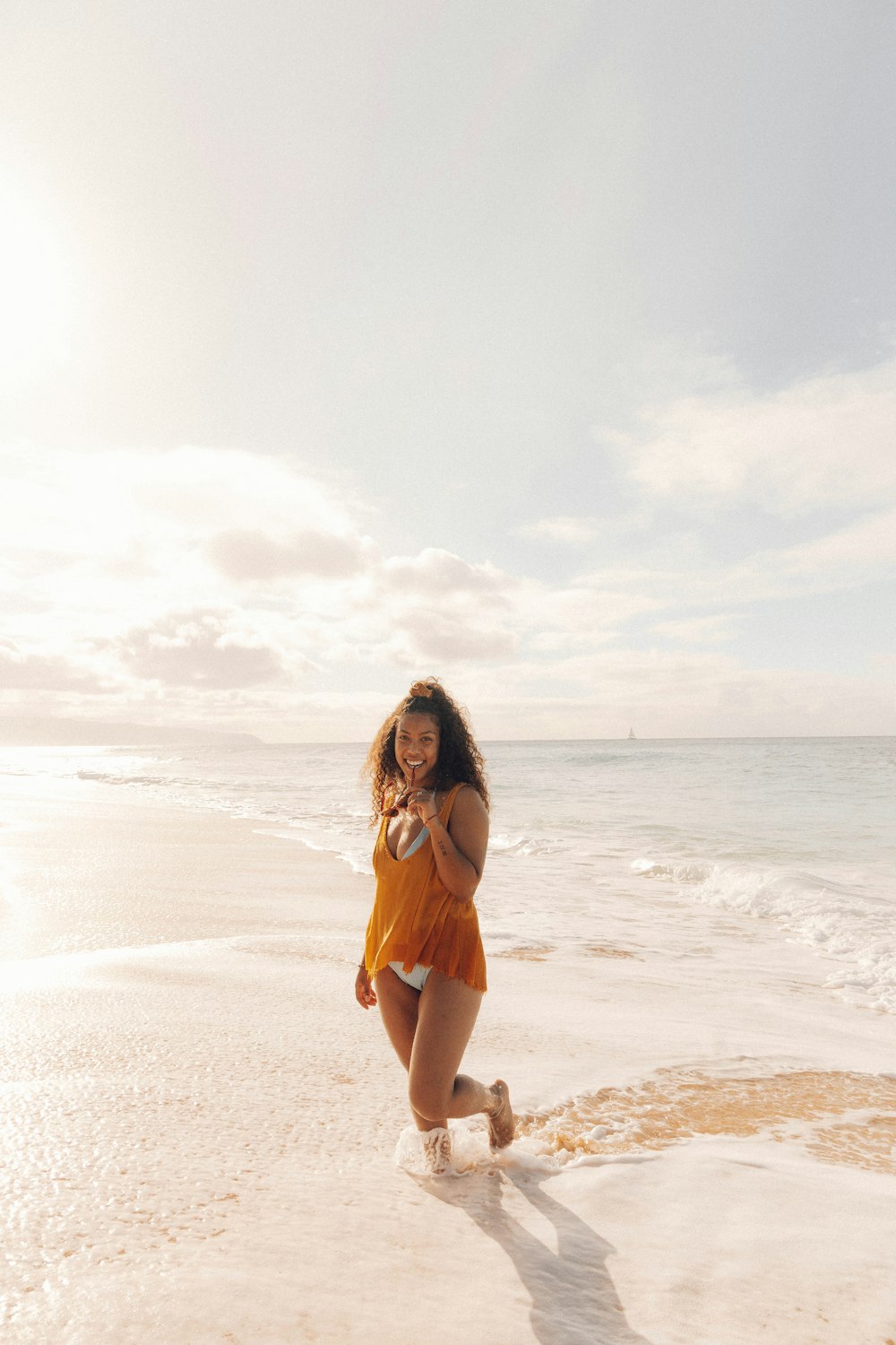 woman in orange bikini standing on beach during daytime