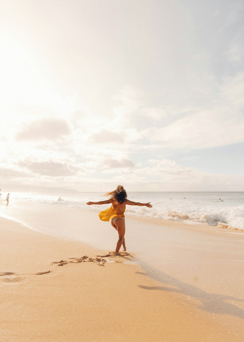 woman in white tank top running on beach during daytime