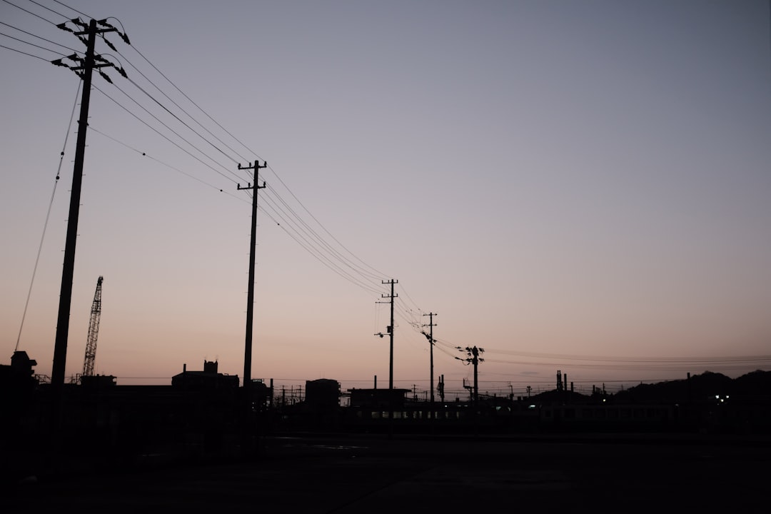 silhouette of electric posts during sunset