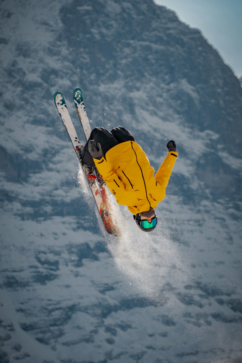 Persona con chaqueta amarilla y pantalones negros montando una tabla de snowboard amarilla en suelo cubierto de nieve durante el día