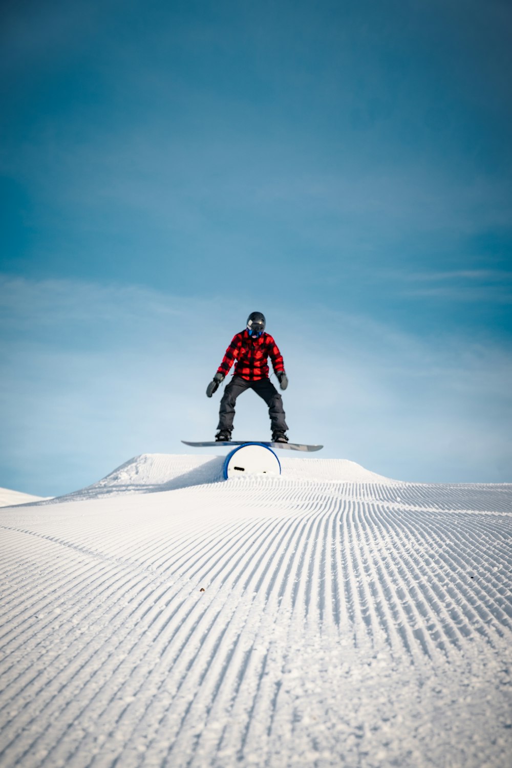 man in red jacket riding white and black bicycle on white sand during daytime