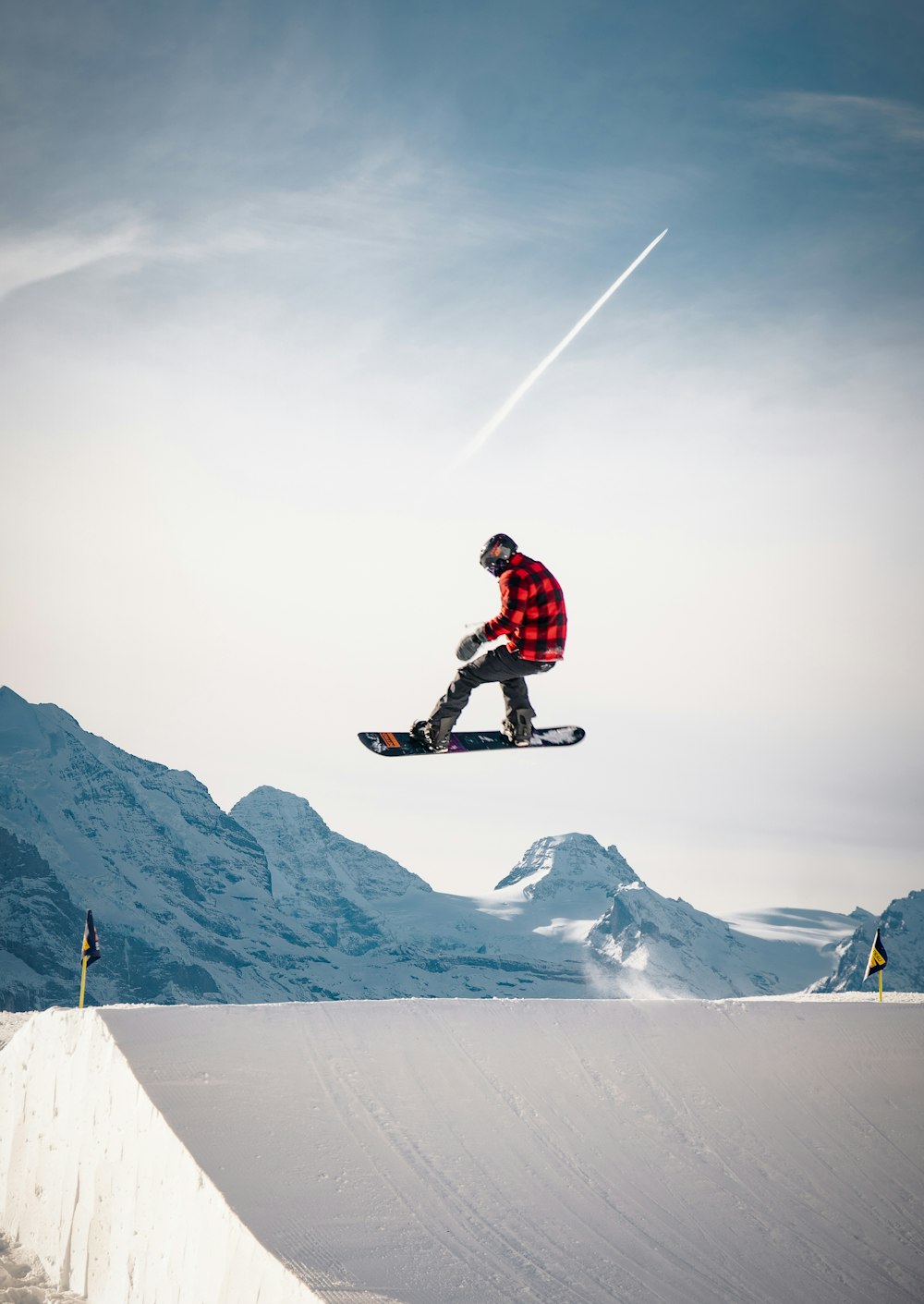 man in red jacket and black pants riding snowboard on snow covered mountain during daytime