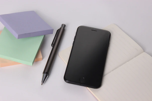 black iphone 4 beside black click pen