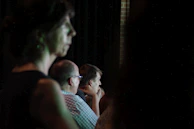 A candid shot of a speaker passionately addressing an engaged audience in a dimly lit venue.