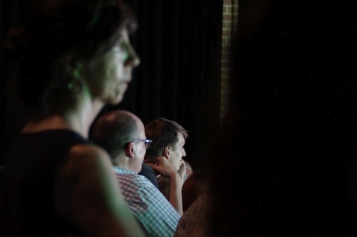 Participants gathered in a bright room attentively listening to a speaker during a social awareness event.