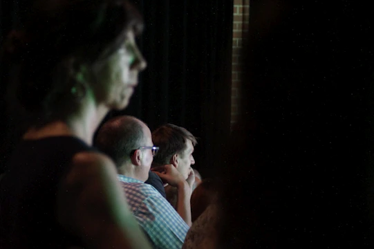 A close-up of a storyteller animatedly sharing tales with an engaged audience in a cozy, softly lit room.
