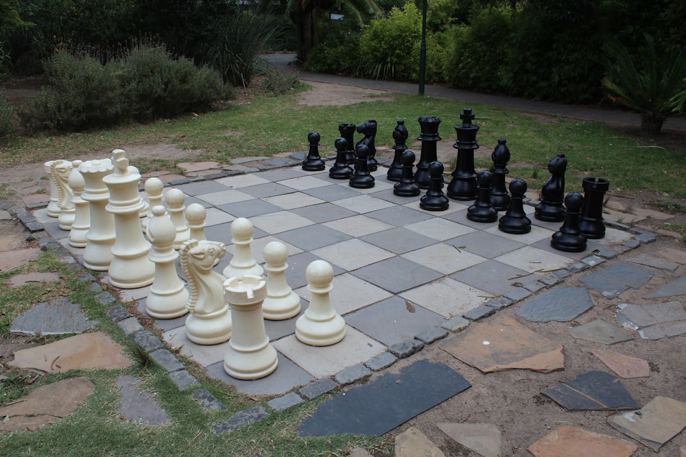 white and black chess pieces on gray concrete floor