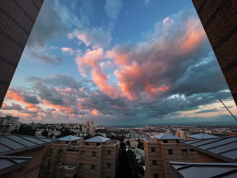 city buildings under blue sky and white clouds during daytime