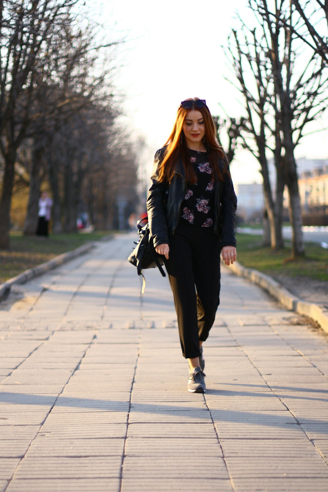 woman in black long sleeve shirt and black pants standing on sidewalk during daytime