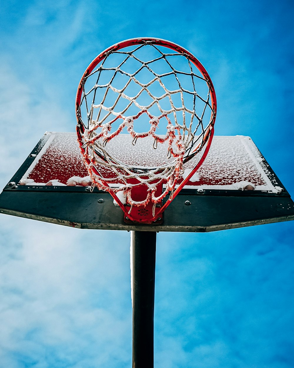 white and red basketball hoop under blue sky during daytime