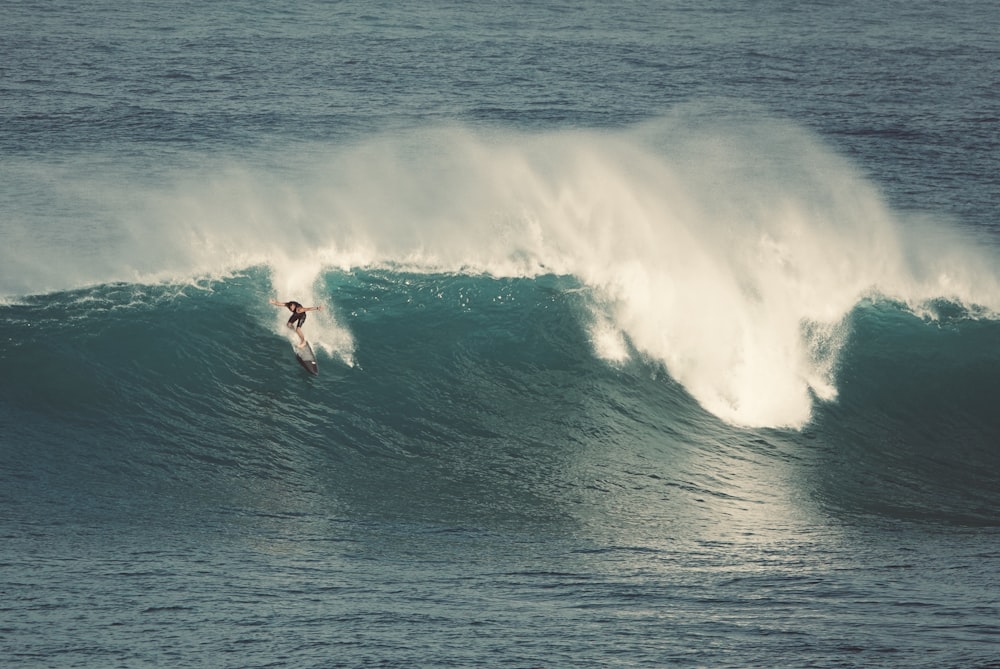 person surfing on sea waves during daytime