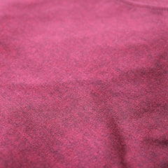 Close-up of textured burgundy and beige fabric showcasing fine stitching and material quality.
