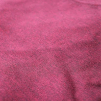 Close-up of high-quality fabric samples in maroon, black, and white colors.
