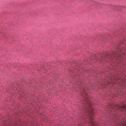 Close-up of textured burgundy and beige fabric showcasing fine stitching and material quality.