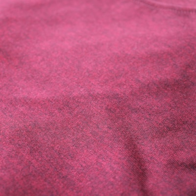 Close-up of a rich maroon kurta fabric showcasing detailed threadwork and fine texture.
